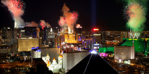 Colorful fireworks light up the night sky above the brightly illuminated hotels and casinos of the Las Vegas Strip—a dazzling highlight among top things To Do In 2017, with glowing buildings and lights reflecting throughout the city.