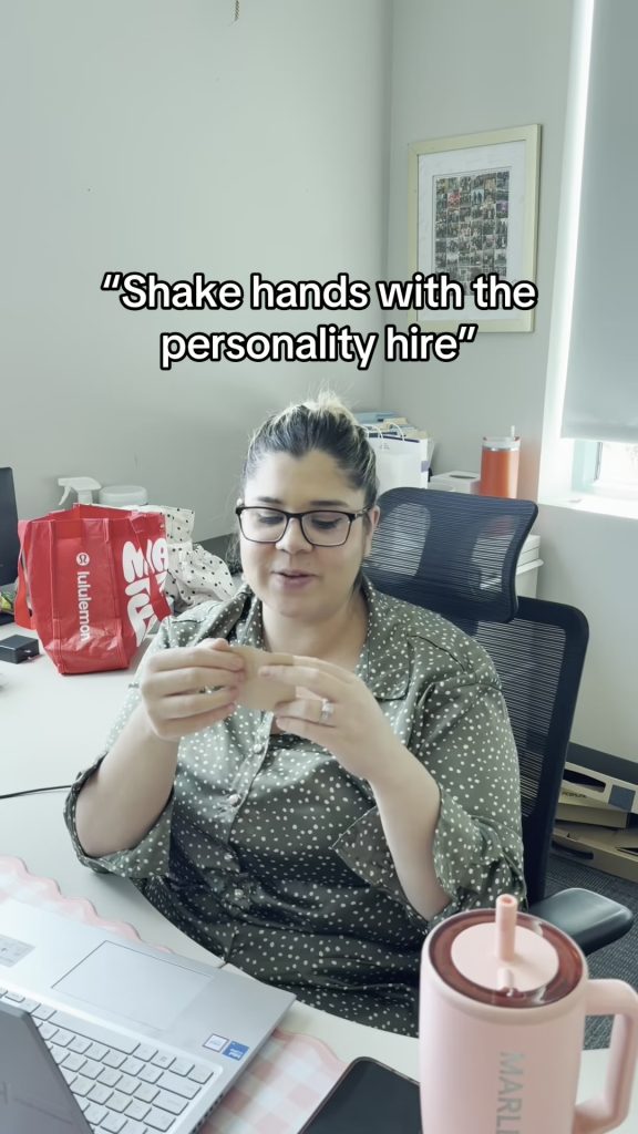 A team member at her desk reads the personality hire prompt in the Abby Connect office