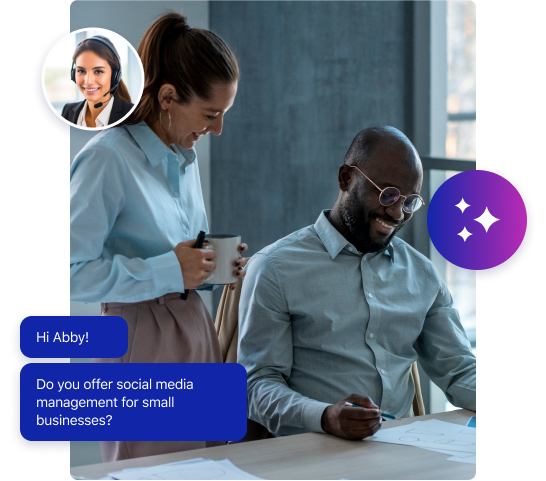 Two colleagues smile while working at a desk with papers. A chat message overlay reads: Hi Abby! Do you offer social media management or business call answering for small businesses? A woman’s photo appears in a small chat profile bubble.