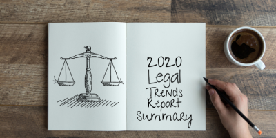 An open notebook on a wooden table shows a drawing of scales of justice on the left page and the handwritten text “2020 Legal Trends Report Summary” on the right, with a hand holding a pencil and a cup of coffee nearby.