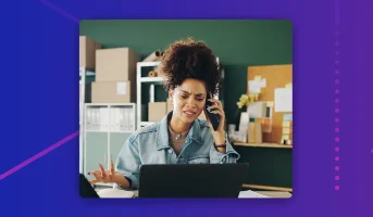 Business owner managing phone calls and work tasks at her desk, highlighting the challenges of handling customer calls while running daily operations.