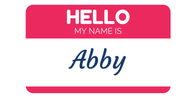 A red and white name tag with the words HELLO MY NAME IS in bold letters and Abby written in cursive script.