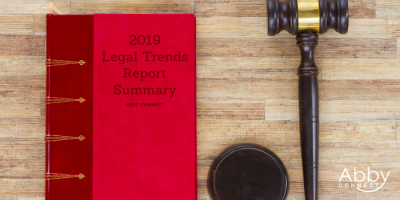 A red book titled 2019 Legal Trends Report Summary lies on a wooden surface next to a judges gavel and sound block. The bottom right corner shows the Abby Connect logo.