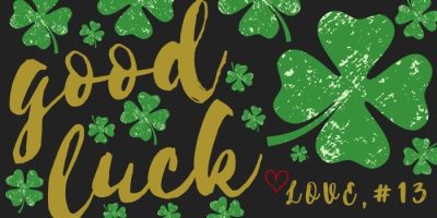 Green shamrocks and the words good luck in large gold script, with love, #13 written in red with a heart, all on a black background.